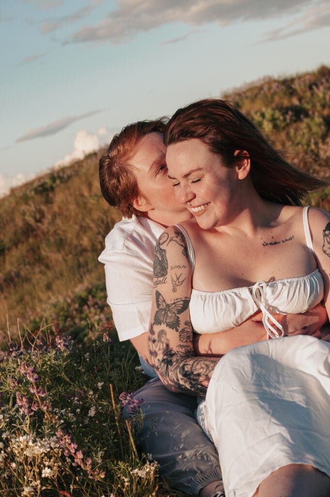 Romantic close-up of engaged couple smiling in a field of purple wildflowers on San Juan Island