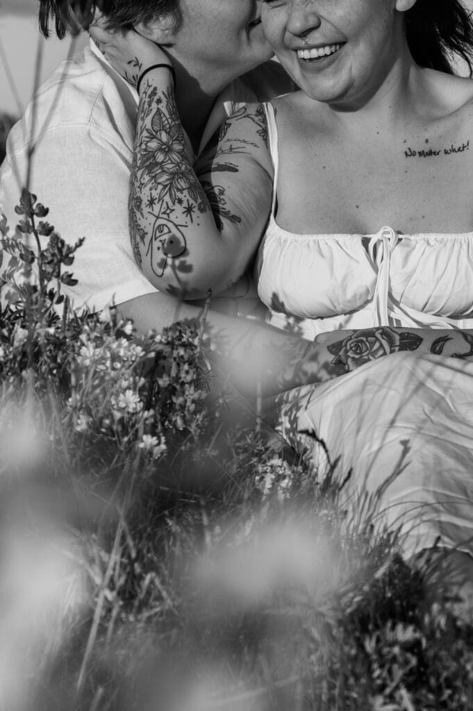 Close-up during candid moment of laughter between couple on a windy cliffside in the San Juan Islands