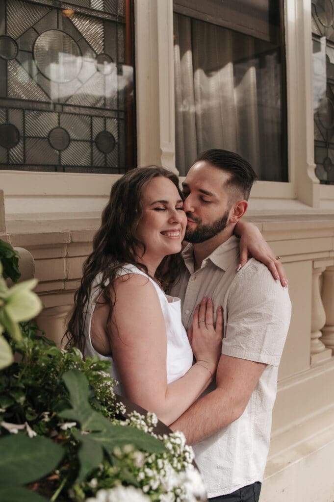 Candid embrace of an engaged couple in Downtown Portland, showcasing genuine emotion in Portland photography.