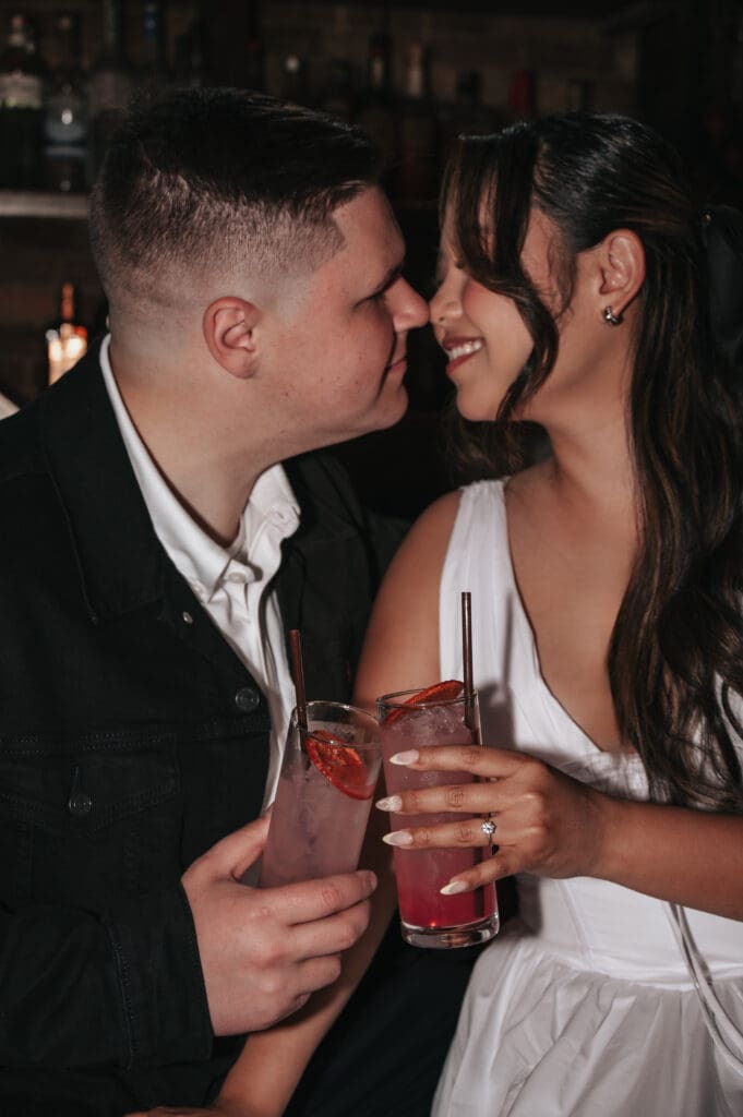 Close-up of engaged couple clinking drinks during bar engagement session in Tacoma