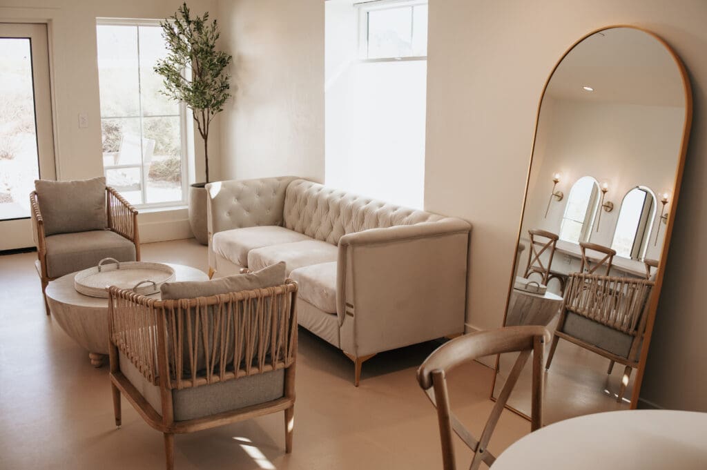 Neutral-toned bridal lounge at Desert View with a mirror and light-filled seating.