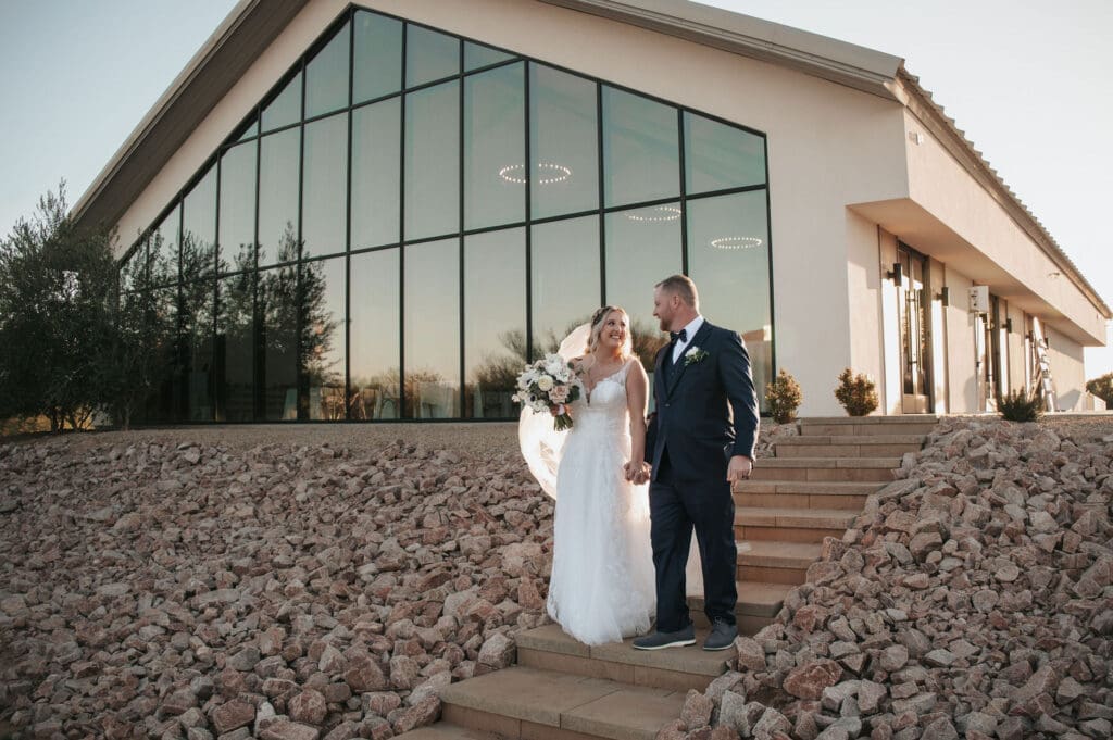 Bride and groom walk down the stairs at Desert View Weddings and Events. 