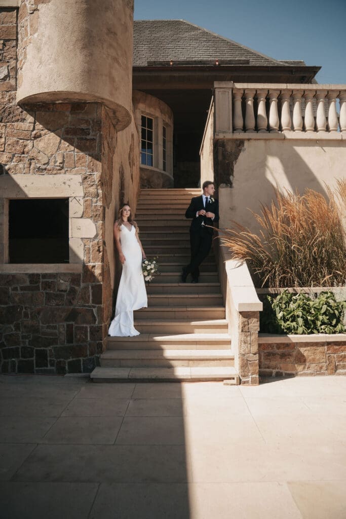 Bride and groom pose editorially on the stairs at the Chateau De Lis in Oregon City, Oregon. 