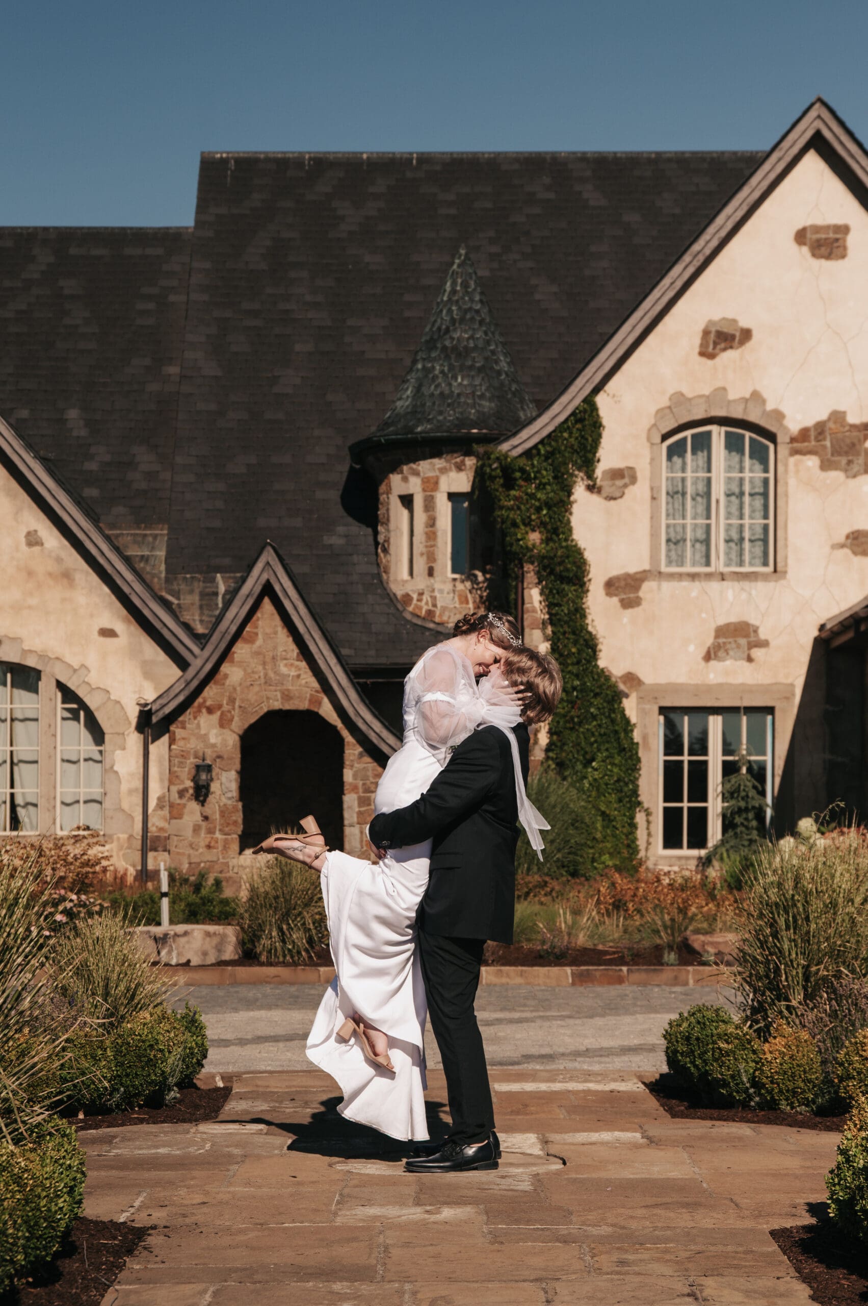 Chateau de Lis luxury wedding venue exterior with couple lovingly kissing in Portland, Oregon