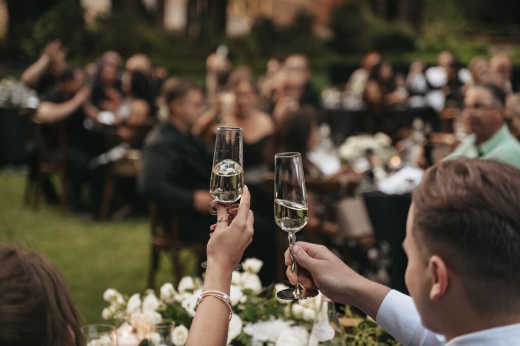 Bride, Groom and their guests raising champagne glasses during an intimate outdoor reception at Nestldown wedding venue in Northern California.