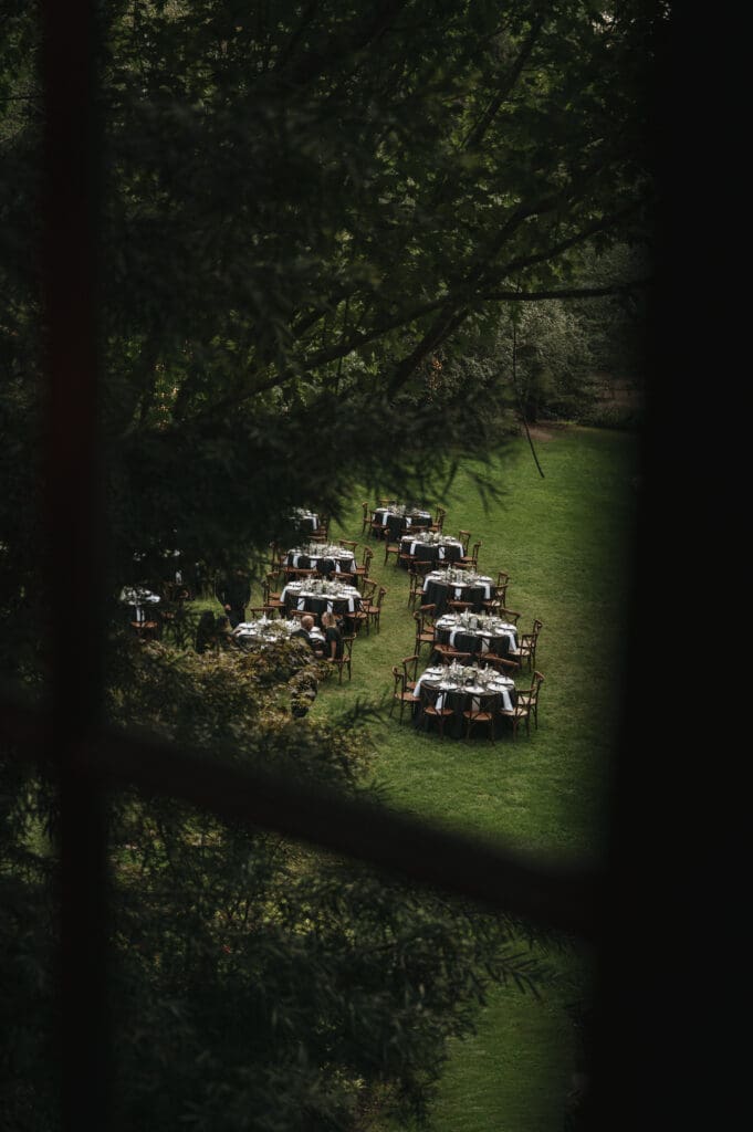 Cinematic overhead view of outdoor reception tables nestled among the trees at Nestldown wedding venue in California.