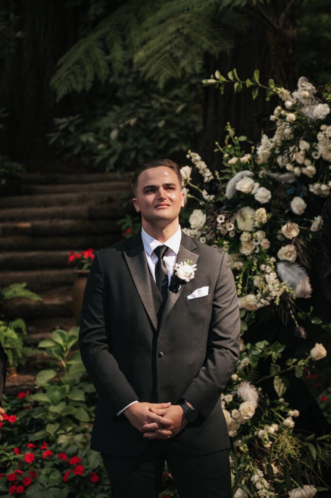 Groom getting emotional during the ceremony at a heartfelt Nestldown wedding while hearing his fiancée's voice.