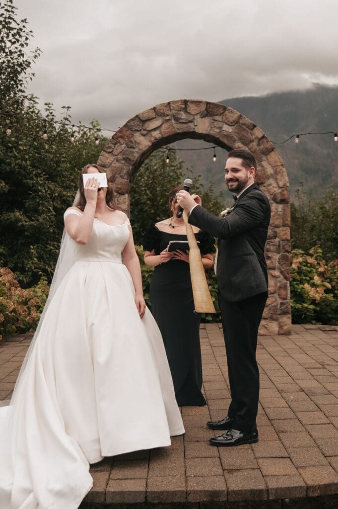 Bride laughs when the length of the grooms' vows on a scroll are revealed.