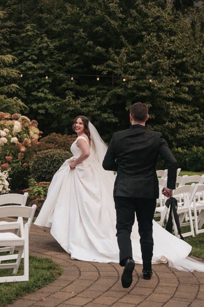 Slightly motion blurred photo where Groom chases the bride cinematically and candidly.