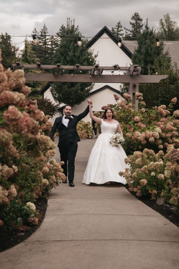 Newlyweds entering their wedding reception surrounded by cheering guests at Cape Horn Estate.