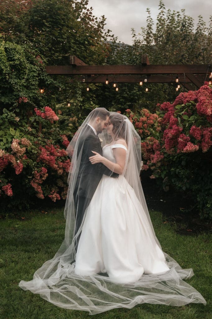 Romantic rainy wedding portrait beneath veil at Cape Horn Estate.