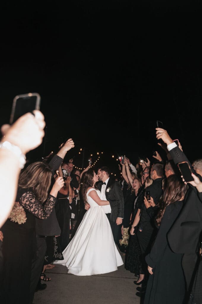 Wedding guests holding phones with flashlights during Cape Horn Estate reception exit