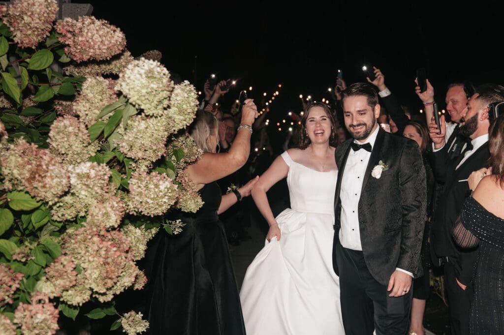 Newlyweds celebrating during nighttime phone light exit at Cape Horn Estate