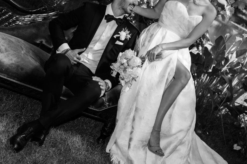 Black and white wedding portrait featuring a stylish couple seated next to each other at Villa Catalana Cellars.