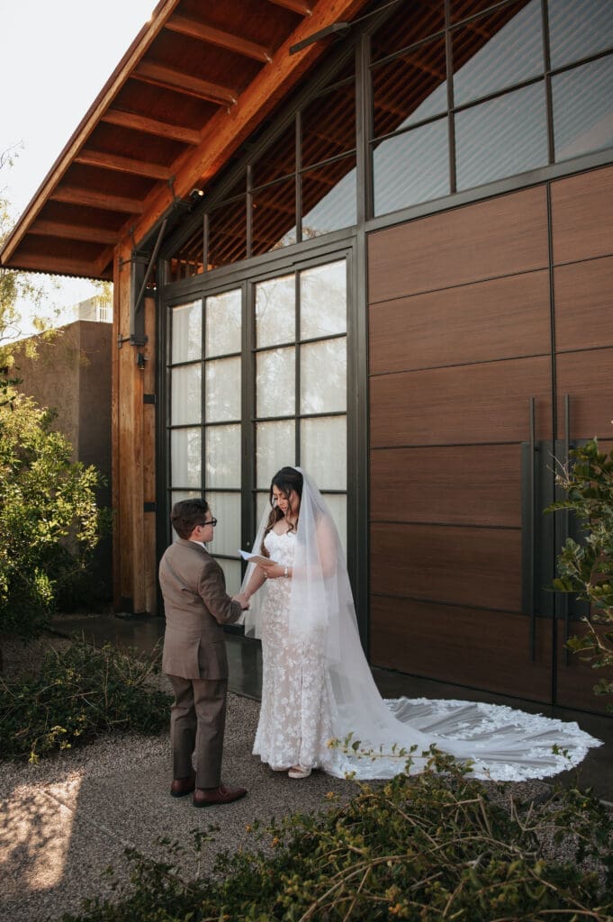 Bride and groom sharing private vows outside the wooden doors at The Paseo Venue in Arizona.