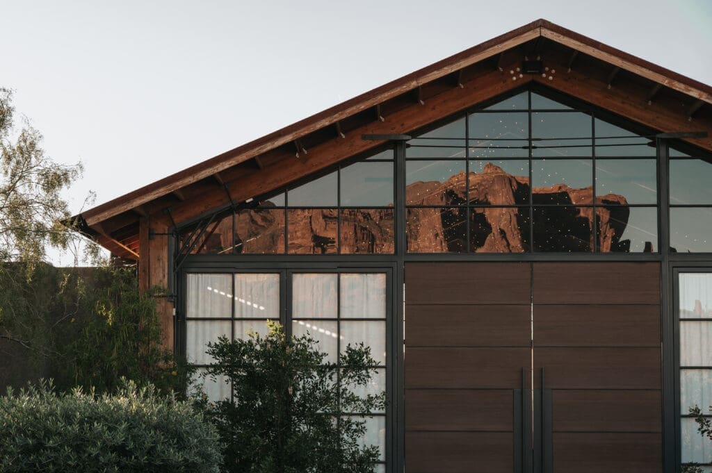 Modern exterior architecture of The Paseo Venue wedding venue in Apache Junction Arizona with reflection of the Superstition Mountains during sunset.