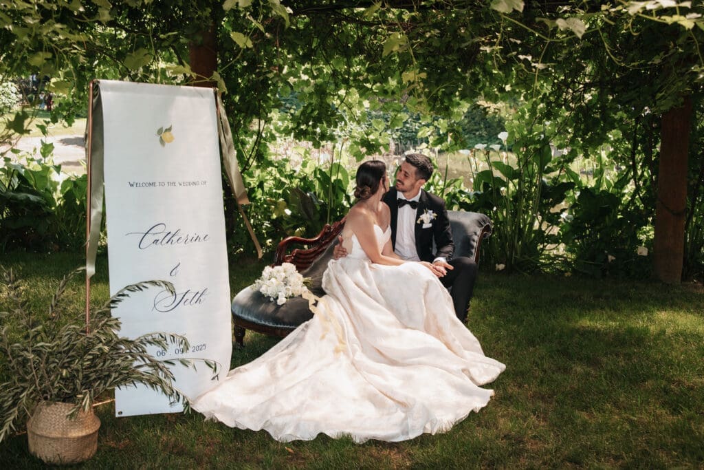 Bride and groom seated together beneath the vines at Villa Catalana Cellars wedding venue.