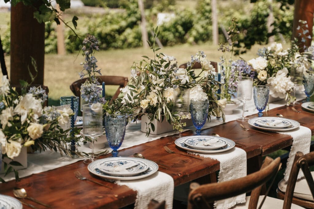Editorial-style reception table details featuring florals and blue glassware at Villa Catalana Cellars.